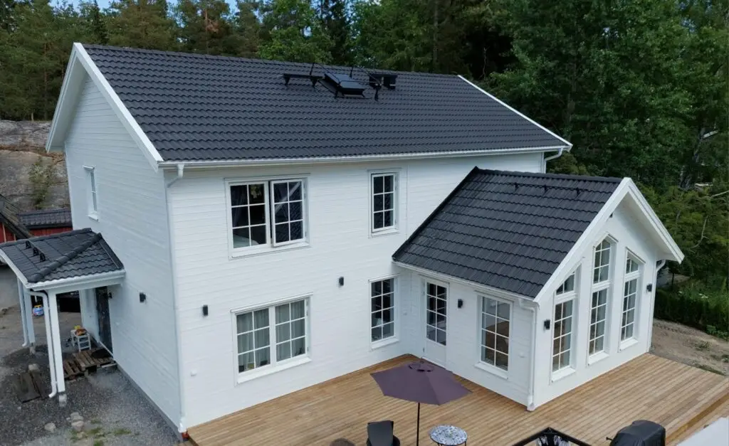 Modern vit villa med nybyggt uterum och rymlig altan av Serving.nu