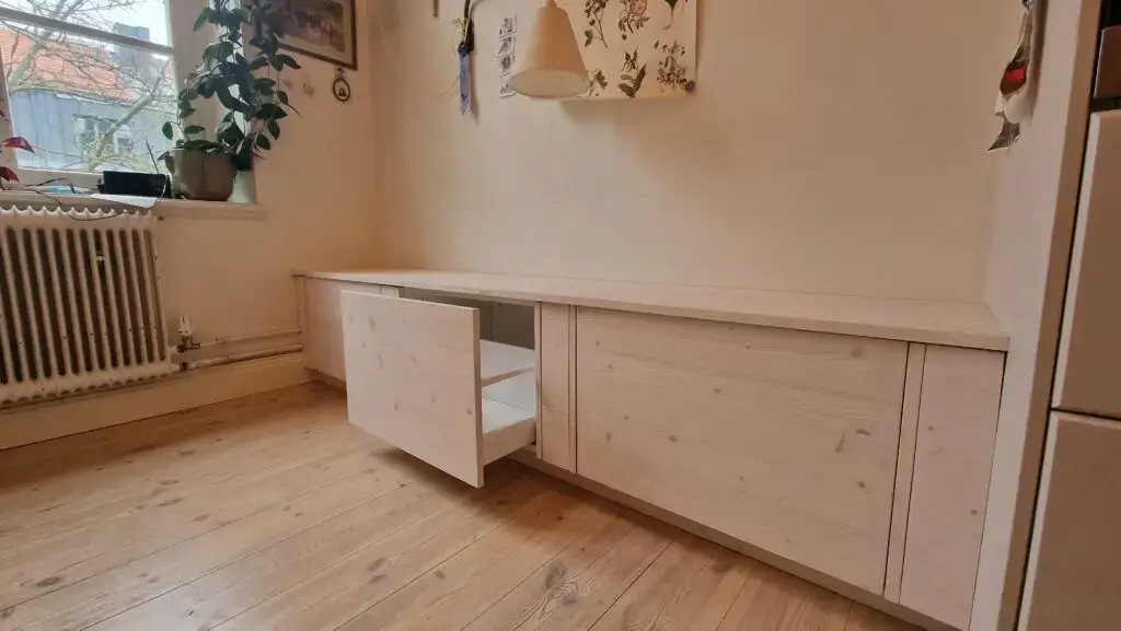 Platsbyggd förvaringslösning i ljust trä med utdragbara lådor, av Serving.nu