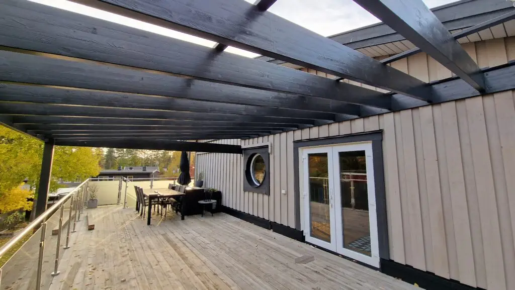Rymlig altan med pergola och loungegrupp, byggd av Serving.nu